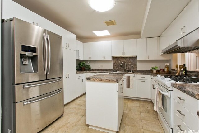 kitchen with white cabinets, stainless steel fridge with ice dispenser, a center island, sink, and white gas range