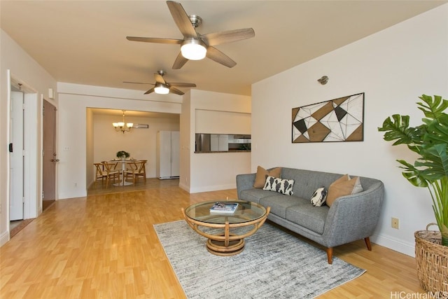 living room featuring ceiling fan with notable chandelier and wood-type flooring