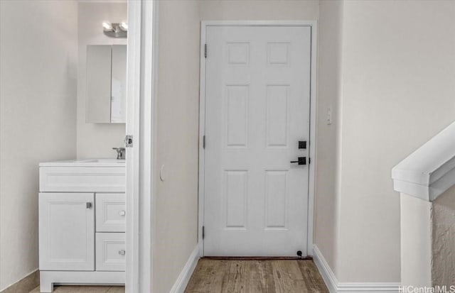 interior space with baseboards, wood finished floors, and vanity