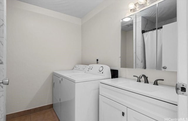 laundry room featuring baseboards, ornamental molding, independent washer and dryer, a sink, and light tile patterned flooring