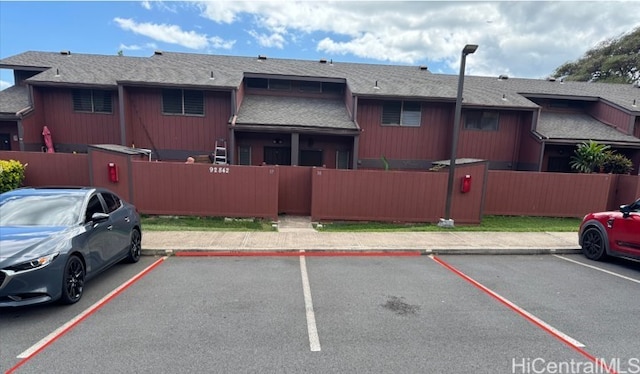 uncovered parking lot featuring a fenced front yard