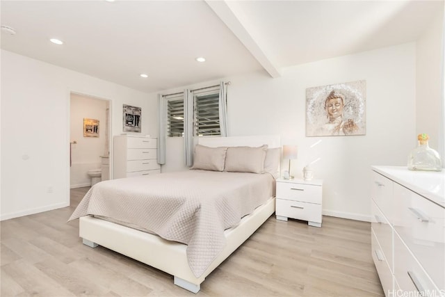 bedroom with connected bathroom, beam ceiling, and light hardwood / wood-style flooring