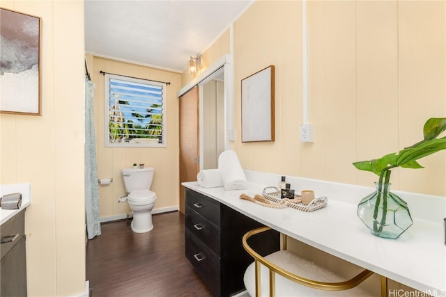 bathroom with crown molding, wood-type flooring, vanity, and toilet