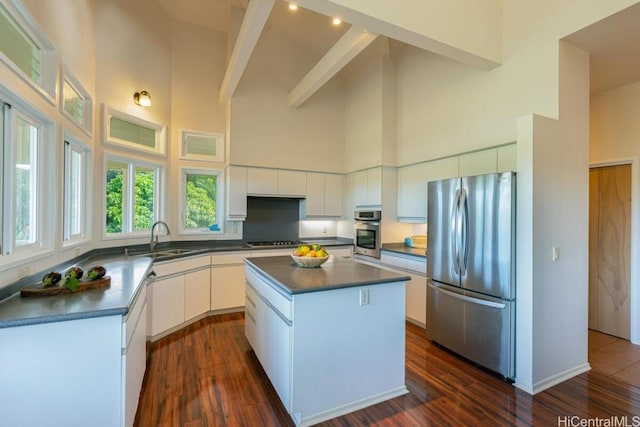 kitchen with a kitchen island, high vaulted ceiling, beam ceiling, white cabinetry, and appliances with stainless steel finishes