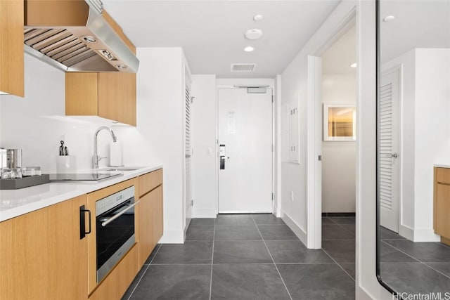 kitchen with sink, ventilation hood, dark tile patterned flooring, black electric stovetop, and oven