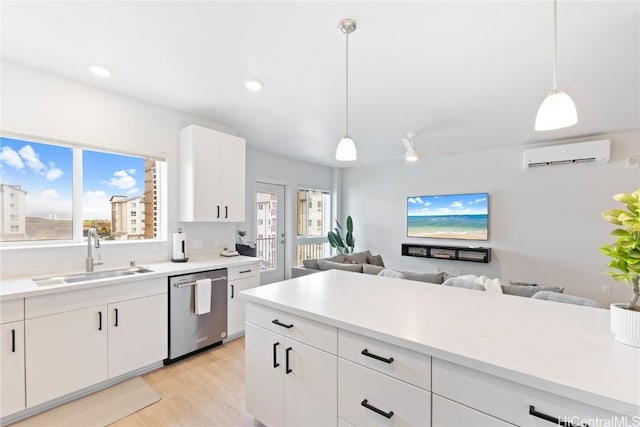 kitchen featuring sink, white cabinetry, hanging light fixtures, a wall mounted AC, and stainless steel dishwasher