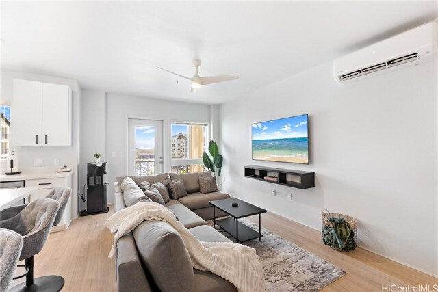 living room featuring an AC wall unit, ceiling fan, and light hardwood / wood-style flooring