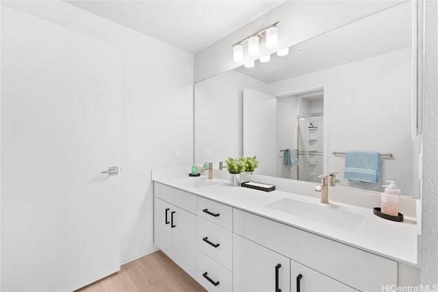 bathroom featuring walk in shower, wood-type flooring, and vanity