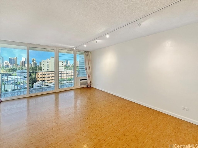 unfurnished room featuring a textured ceiling and hardwood / wood-style floors