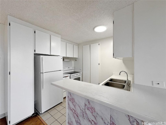 kitchen with light tile patterned floors, white cabinetry, white appliances, a textured ceiling, and sink