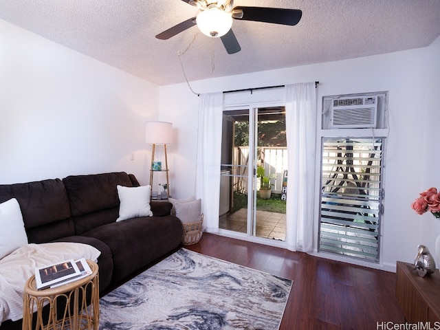 living room with a wall unit AC, a textured ceiling, ceiling fan, and dark wood-type flooring