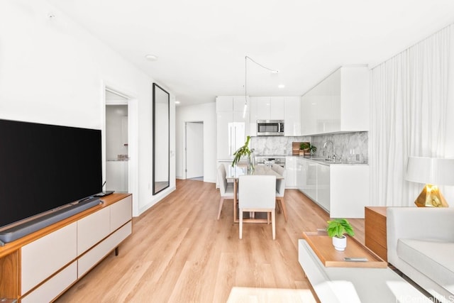 living room with light hardwood / wood-style flooring and sink