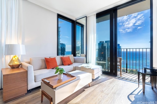 living room with hardwood / wood-style floors, a wall of windows, and a water view