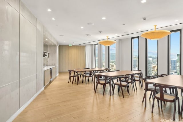 dining area featuring light wood-type flooring and floor to ceiling windows