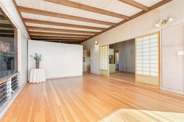 unfurnished living room with vaulted ceiling with beams, wood ceiling, and hardwood / wood-style flooring