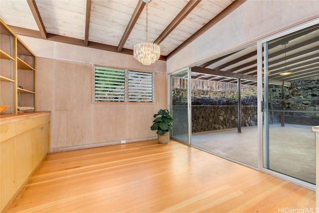 interior space with a notable chandelier, wood-type flooring, vaulted ceiling with beams, and wooden ceiling