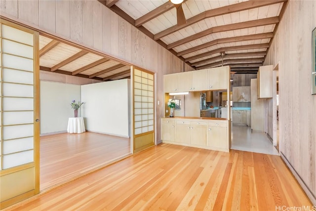 unfurnished living room with beamed ceiling, high vaulted ceiling, and light hardwood / wood-style flooring