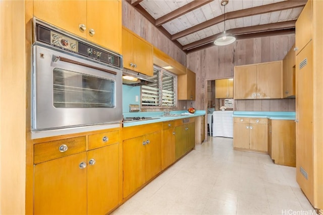 kitchen featuring sink, wooden walls, white gas stovetop, wooden ceiling, and oven