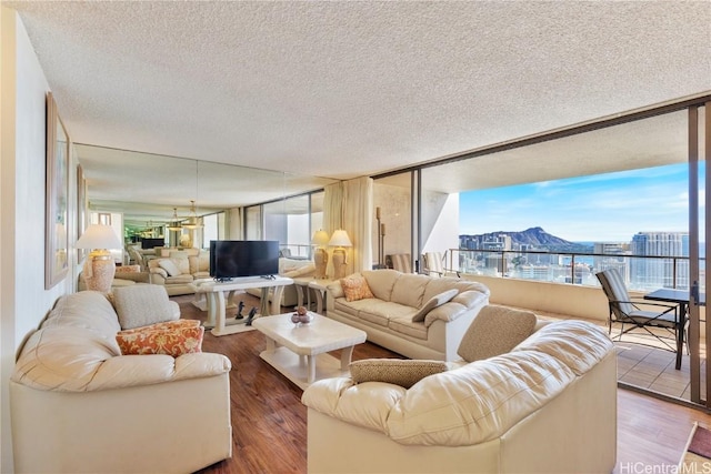 living room featuring a textured ceiling, hardwood / wood-style flooring, and a notable chandelier