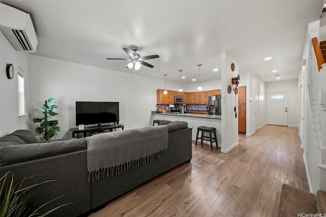 478 Kunehi St Unit 105, Kapolei, HI 96707 - living area with a wall unit AC, light wood finished floors, recessed lighting, a ceiling fan, and baseboards