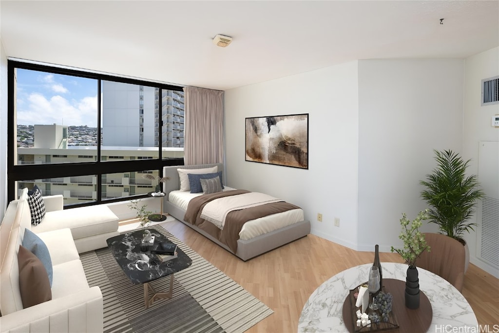 bedroom featuring expansive windows and light hardwood / wood-style flooring