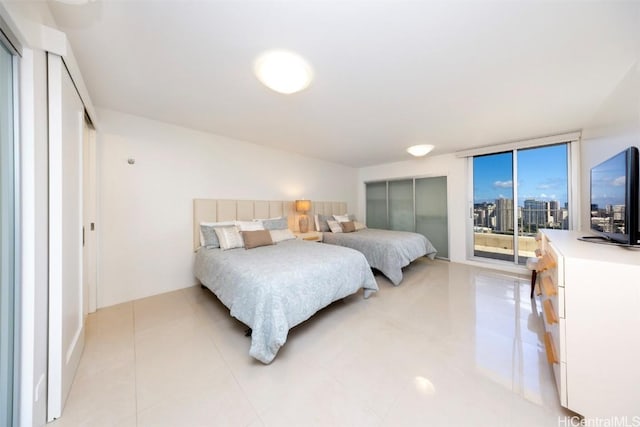 tiled bedroom with floor to ceiling windows and access to exterior