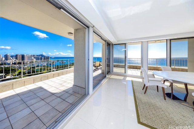 sunroom featuring a water view