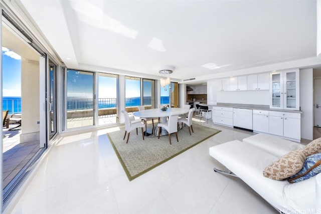 dining space featuring a water view, expansive windows, and light tile patterned floors