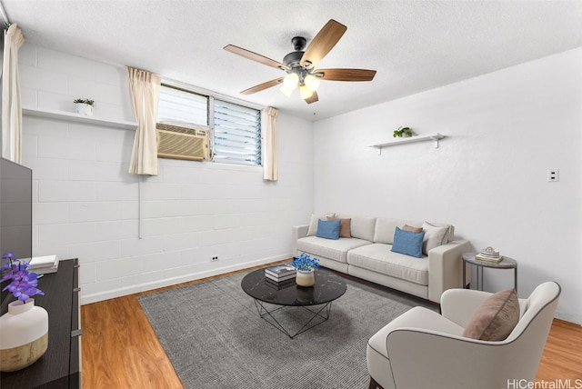 living room featuring a textured ceiling, ceiling fan, cooling unit, and hardwood / wood-style flooring