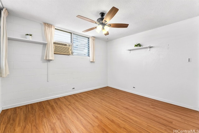 unfurnished room featuring ceiling fan, wood-type flooring, a textured ceiling, and cooling unit