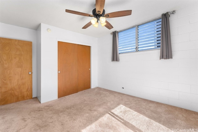 unfurnished bedroom featuring ceiling fan, a closet, and carpet floors