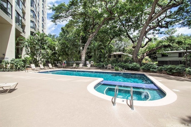 view of pool with a patio area and a hot tub