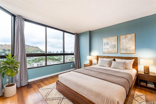 bedroom featuring hardwood / wood-style floors and a mountain view