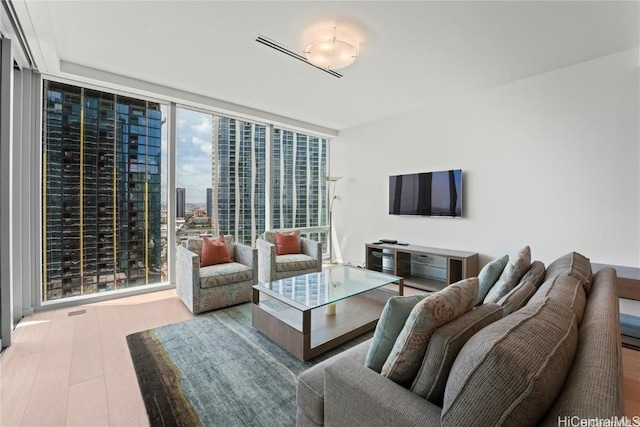 living room featuring expansive windows and light hardwood / wood-style floors