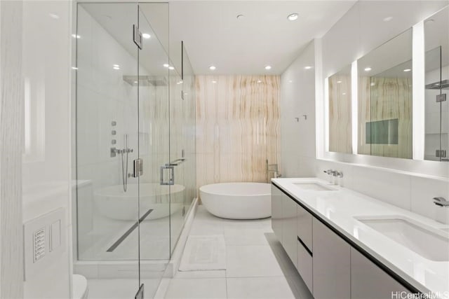 bathroom with independent shower and bath, vanity, and tile walls