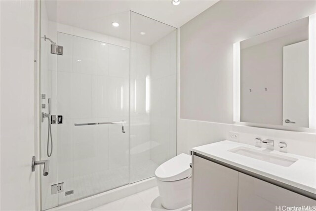 bathroom with vanity, a shower with door, and toilet