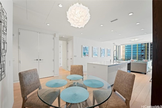 dining area featuring sink and light hardwood / wood-style flooring