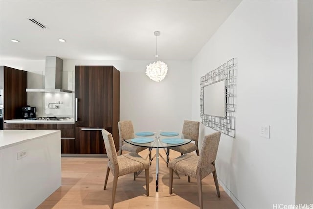 dining space with a chandelier and light hardwood / wood-style floors