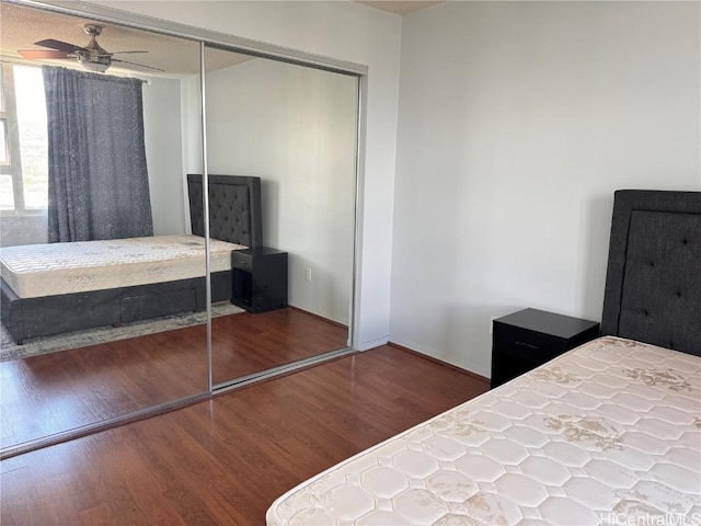 unfurnished bedroom with ceiling fan, dark hardwood / wood-style flooring, and a closet