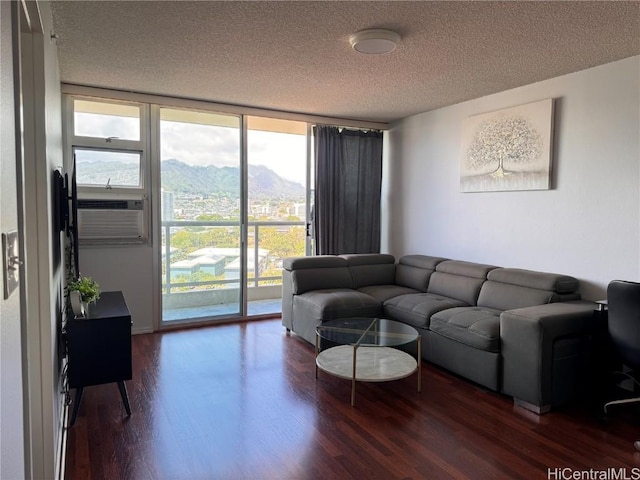 living room with floor to ceiling windows, a textured ceiling, a mountain view, and dark hardwood / wood-style floors