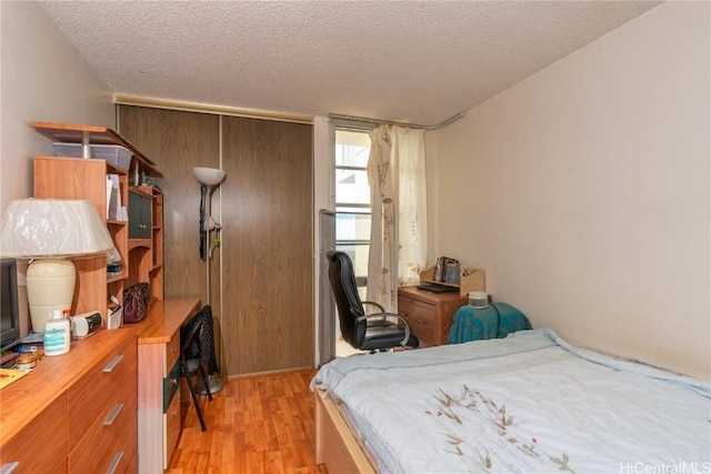 bedroom featuring a textured ceiling and light wood-type flooring