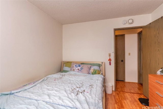 bedroom featuring a textured ceiling and light hardwood / wood-style floors