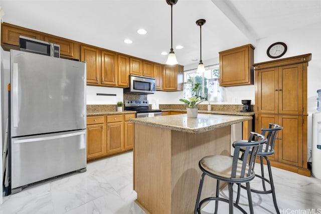 kitchen with pendant lighting, light stone countertops, a kitchen island, a breakfast bar, and appliances with stainless steel finishes