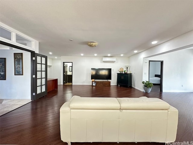 living room with a wall mounted AC and dark hardwood / wood-style floors