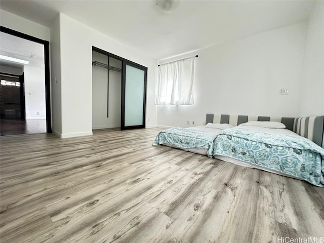 bedroom with wood-type flooring and a closet