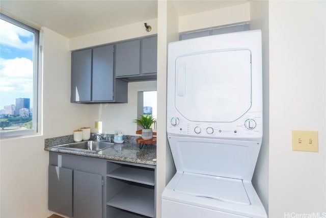 laundry room with sink and stacked washer / dryer