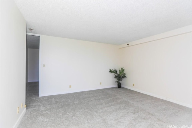 unfurnished room with a textured ceiling and light carpet