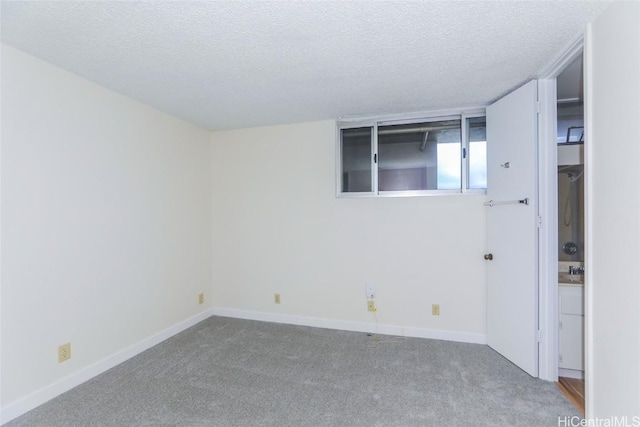 carpeted spare room with a textured ceiling