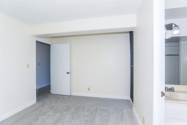 unfurnished bedroom featuring a textured ceiling and light carpet