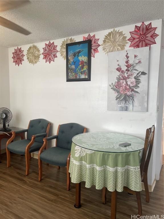 dining room with a textured ceiling and wood-type flooring